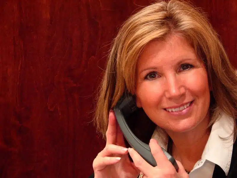 Kvinde smiler mens hun taler i telefon